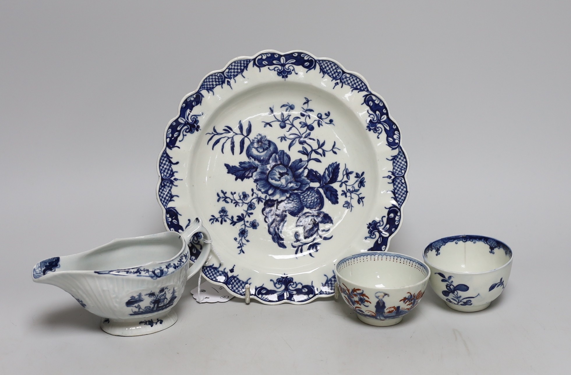 An 18th century Lowestoft sauceboat and a Worcester pine cone pattern plate and two tea bowls, dish 21cms diameter
